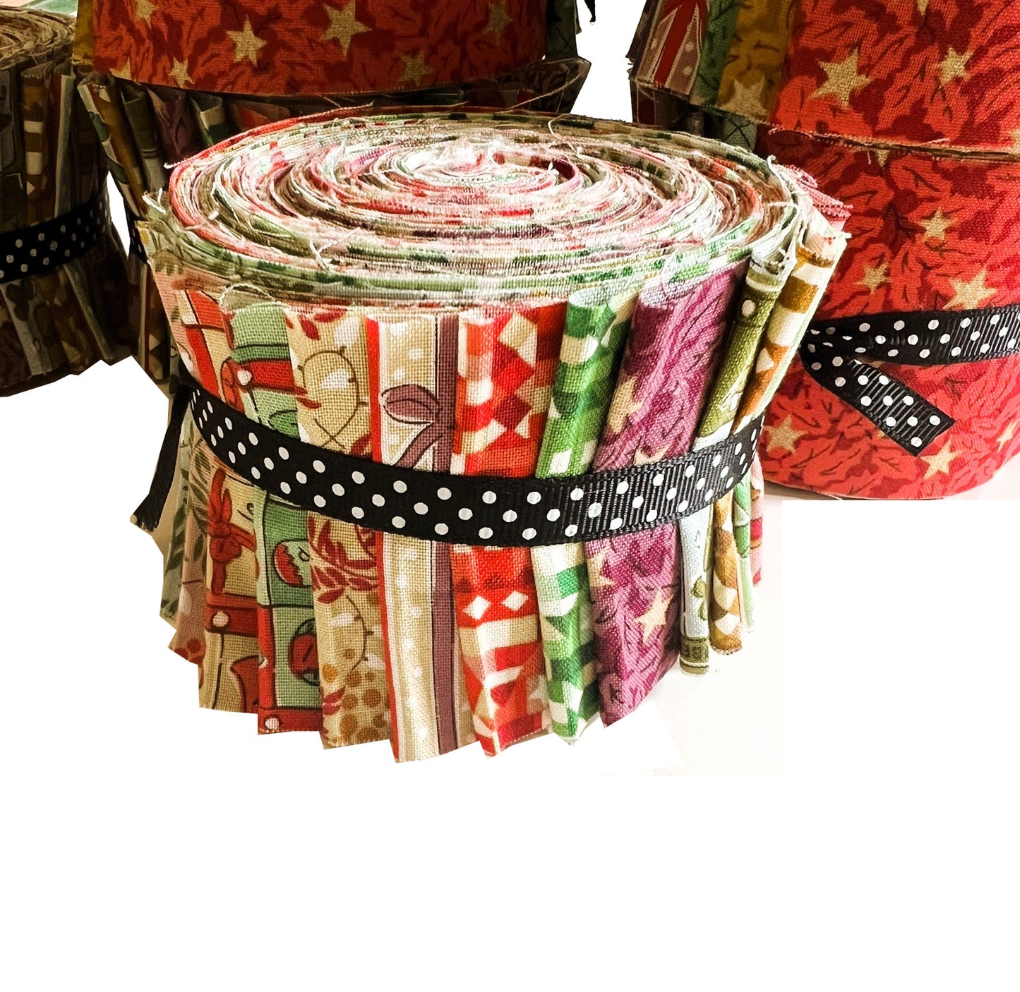 A roll of fabric cut into small pieces, tied with a black and white polka dot ribbon, shown against a white background with other fabric rolls partially visible behind it.